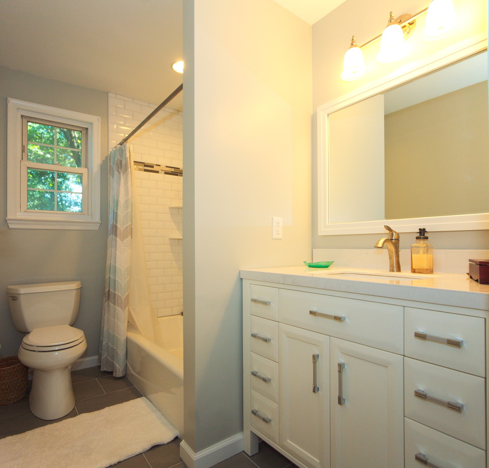 Design ideas for a small classic family bathroom in Philadelphia with freestanding cabinets, white cabinets, an alcove bath, a shower/bath combination, a two-piece toilet, white tiles, ceramic tiles, grey walls, porcelain flooring, a submerged sink and limestone worktops.