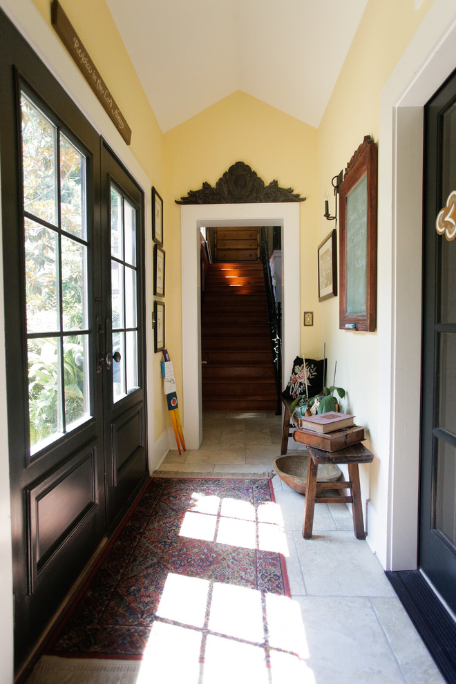 This is an example of a country entry hall in Other with yellow walls and beige floor.