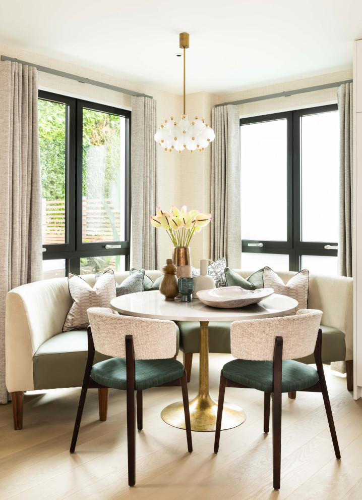 This is an example of a contemporary dining room in London with beige walls, light hardwood floors and beige floor.