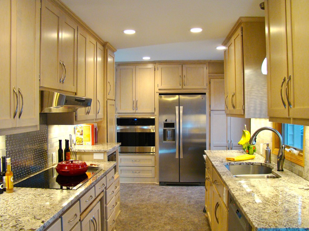 Design ideas for a mid-sized traditional galley eat-in kitchen in Minneapolis with an undermount sink, flat-panel cabinets, light wood cabinets, granite benchtops, beige splashback, stone tile splashback, stainless steel appliances, linoleum floors and no island.