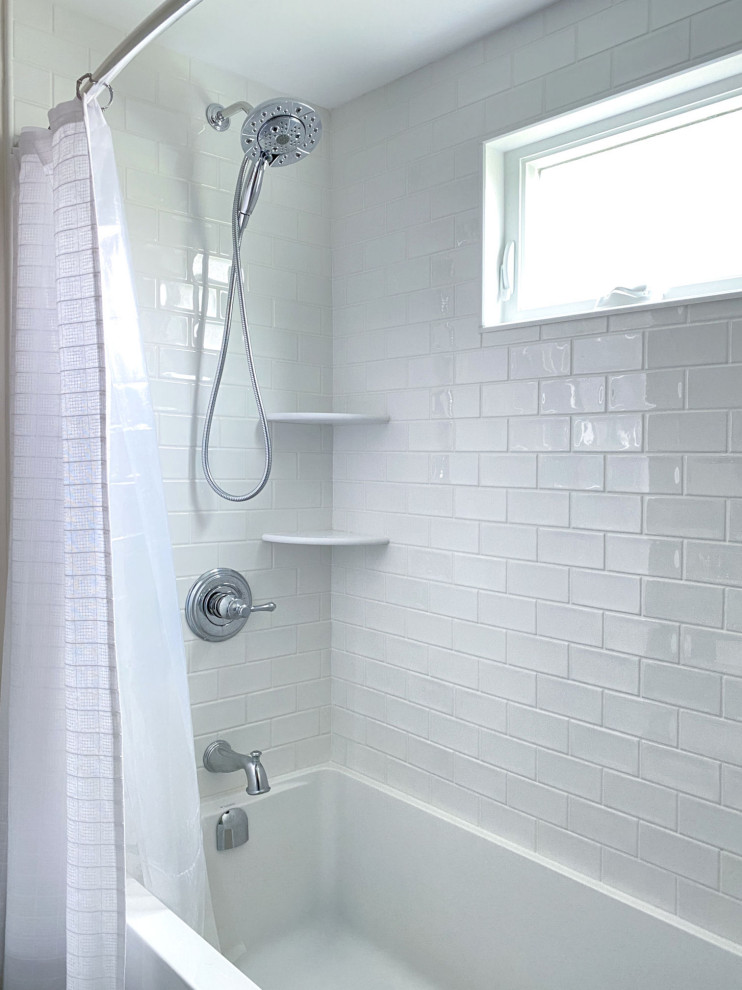 Идея дизайна: ванная комната в стиле неоклассика (современная классика) с фасадами с выступающей филенкой, синими фасадами, душем над ванной, раздельным унитазом, белой плиткой, керамической плиткой, белыми стенами, полом из керамогранита, врезной раковиной, столешницей из искусственного кварца, бежевым полом, шторкой для ванной, белой столешницей, тумбой под одну раковину и встроенной тумбой
