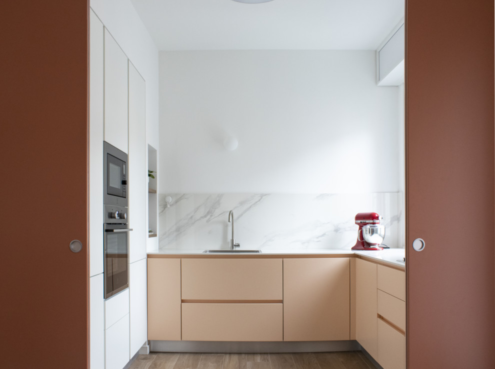 Design ideas for a medium sized contemporary u-shaped enclosed kitchen in Milan with a built-in sink, beaded cabinets, orange cabinets, tile countertops, white splashback, ceramic splashback, stainless steel appliances, ceramic flooring, brown floors and white worktops.