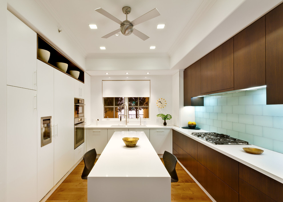 Photo of a mid-sized contemporary l-shaped separate kitchen in Los Angeles with flat-panel cabinets, dark wood cabinets, blue splashback, glass tile splashback, panelled appliances, medium hardwood floors and with island.
