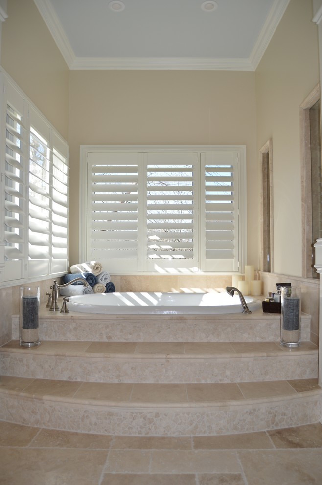 Inspiration for a large transitional master bathroom in Atlanta with an undermount sink, raised-panel cabinets, white cabinets, limestone benchtops, a drop-in tub, a double shower, a one-piece toilet, beige tile, stone tile, beige walls and limestone floors.