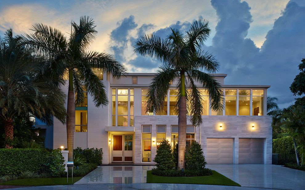 This is an example of an expansive contemporary split-level beige exterior in Miami with a flat roof and mixed siding.