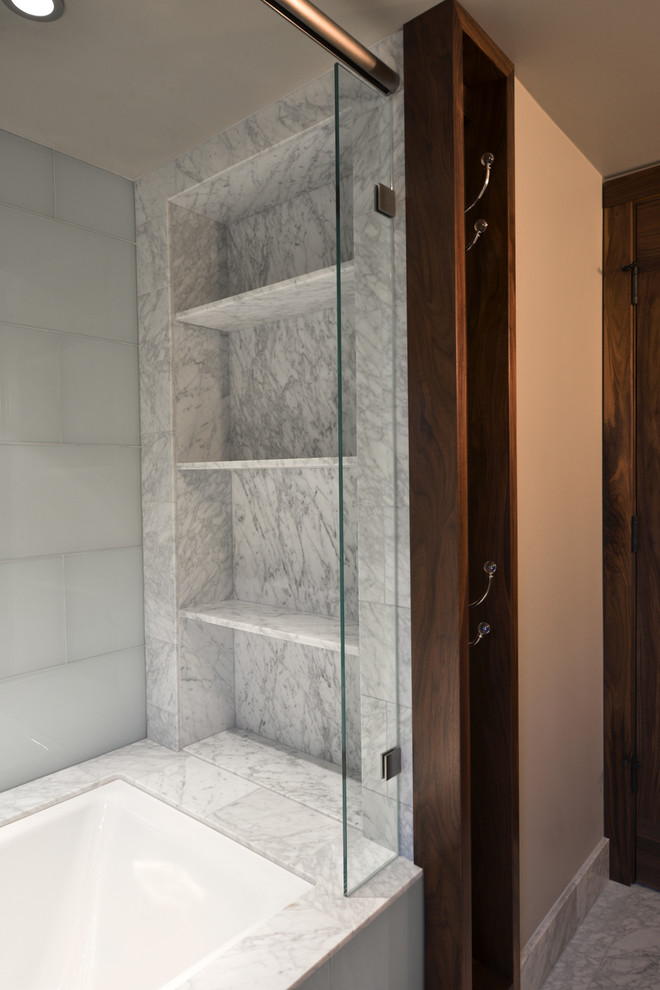 Transitional bathroom in San Francisco with an undermount sink, shaker cabinets, medium wood cabinets, marble benchtops, an alcove tub, a shower/bathtub combo, a one-piece toilet, green tile, glass tile, grey walls and marble floors.