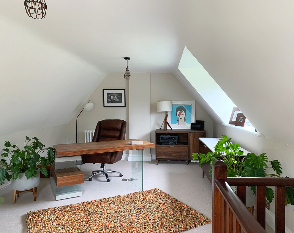 This is an example of a midcentury study room in Gloucestershire with beige walls and carpet.
