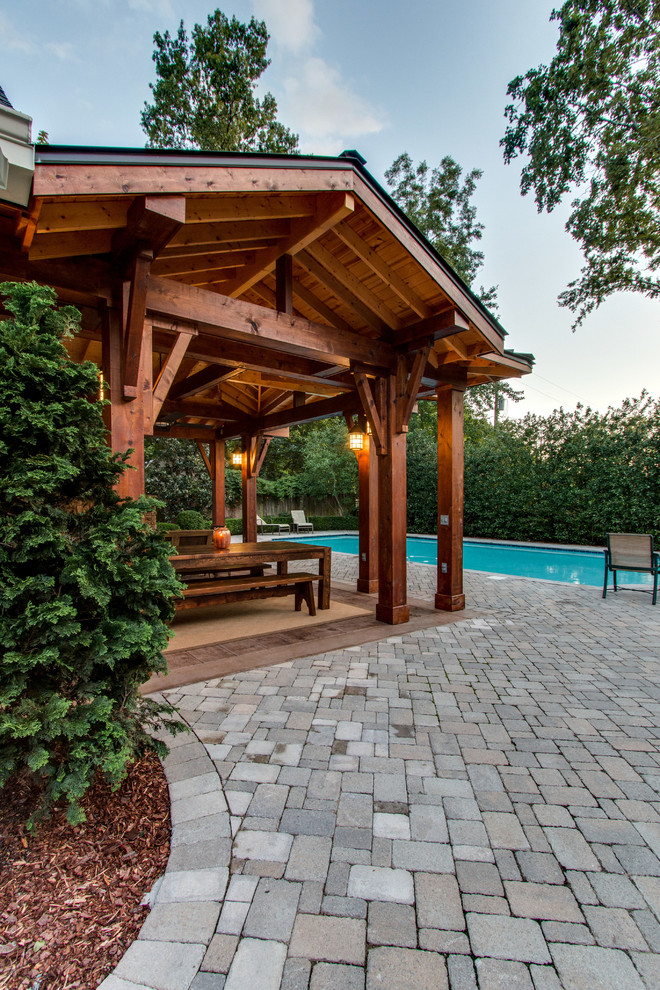 Photo of a large country backyard patio in Nashville with a fire feature, brick pavers and a pergola.