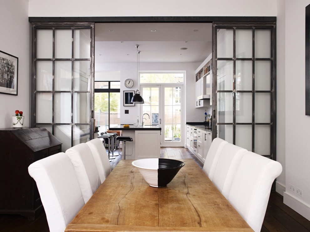 This is an example of a large contemporary eat-in kitchen in London with shaker cabinets, black appliances and with island.