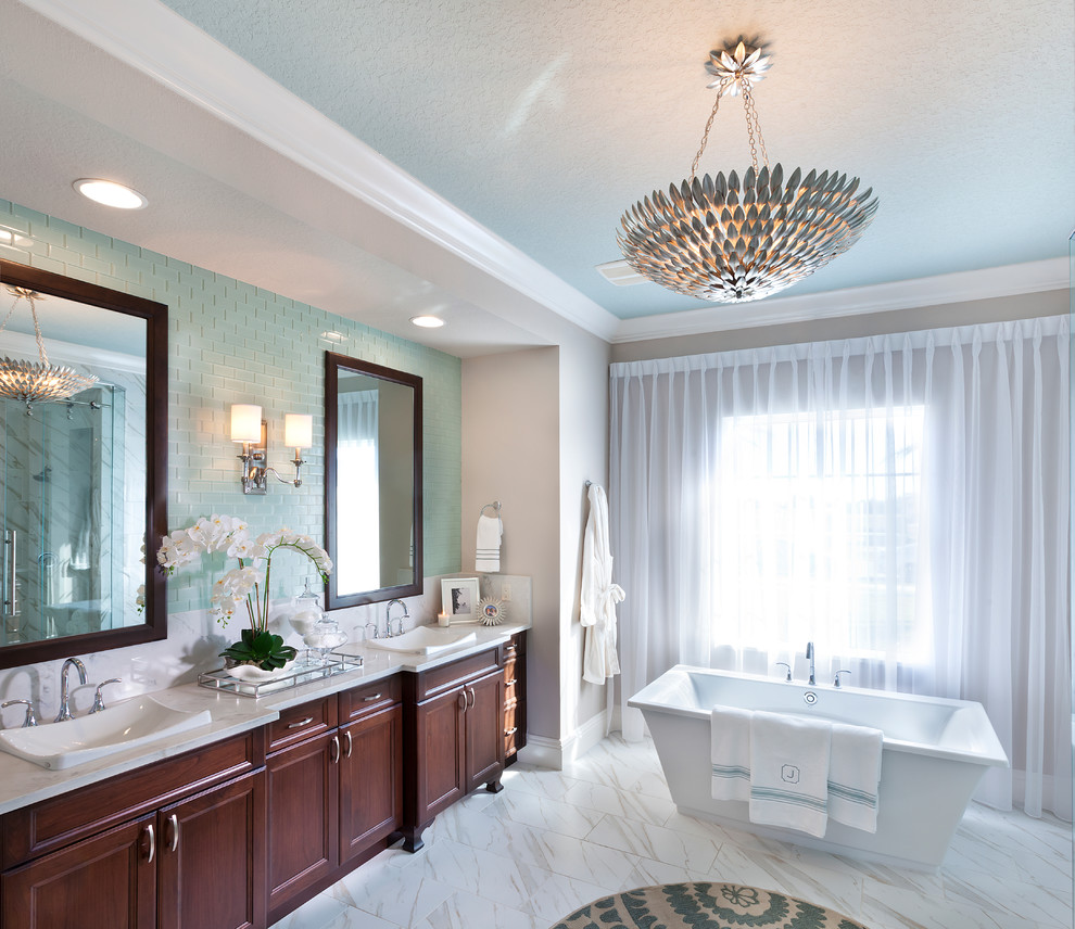 Design ideas for an expansive contemporary master bathroom in Tampa with recessed-panel cabinets, brown cabinets, a freestanding tub, a double shower, a two-piece toilet, blue tile, subway tile, beige walls, porcelain floors, a pedestal sink, white floor and a sliding shower screen.