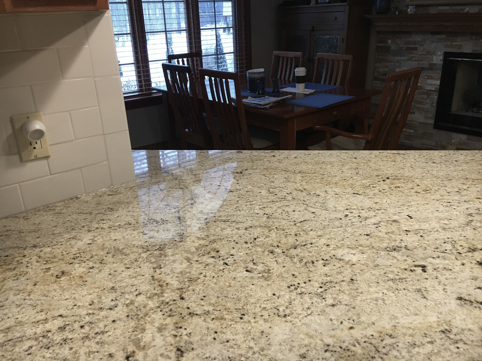 Inspiration for a large transitional u-shaped medium tone wood floor eat-in kitchen remodel with an undermount sink, raised-panel cabinets, medium tone wood cabinets, granite countertops, white backsplash, ceramic backsplash, stainless steel appliances and an island