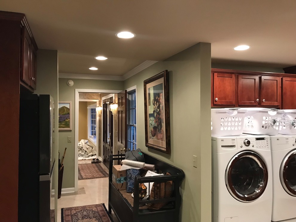 Photo of a mid-sized traditional galley dedicated laundry room in Chicago with an utility sink, raised-panel cabinets, dark wood cabinets, marble benchtops, green walls, marble floors, a side-by-side washer and dryer, beige floor and multi-coloured benchtop.