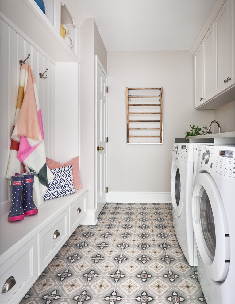 Inspiration for a mid-sized transitional galley utility room in Charlotte with recessed-panel cabinets, white cabinets, grey walls, a side-by-side washer and dryer, multi-coloured floor and grey benchtop.