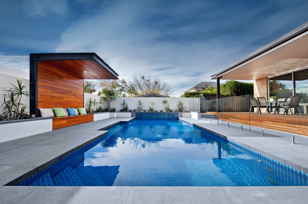 Inspiration for a large contemporary backyard custom-shaped pool in Adelaide with natural stone pavers.