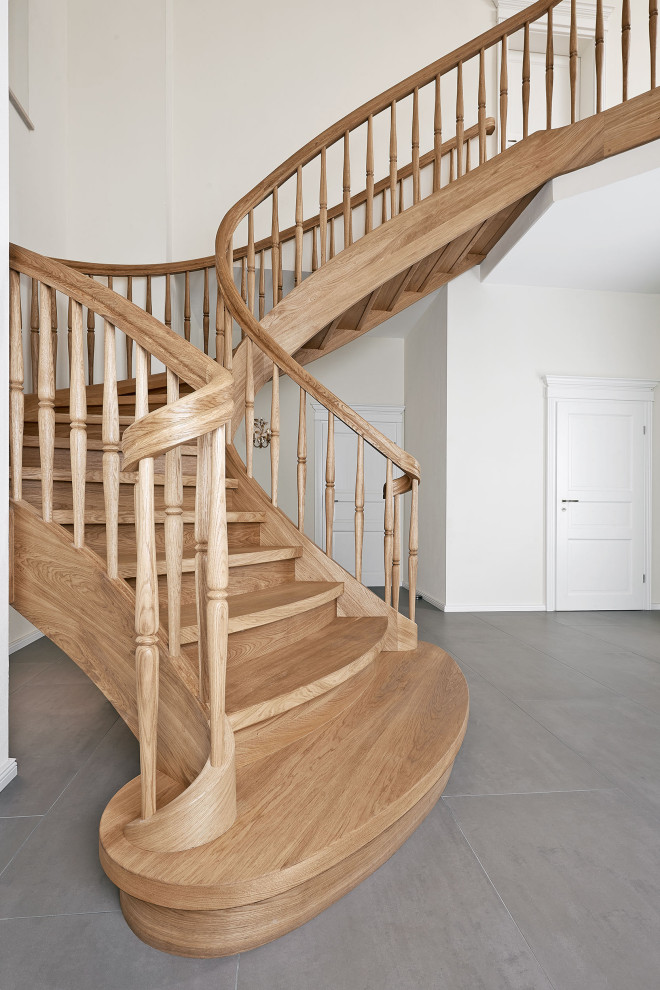 Imagen de escalera curva campestre con escalones de madera, contrahuellas de madera y barandilla de madera