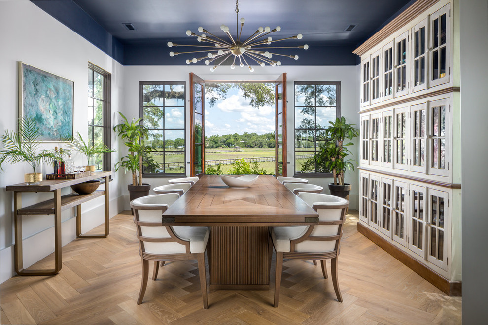 Mediterranean separate dining room in Charleston with white walls, medium hardwood floors and brown floor.