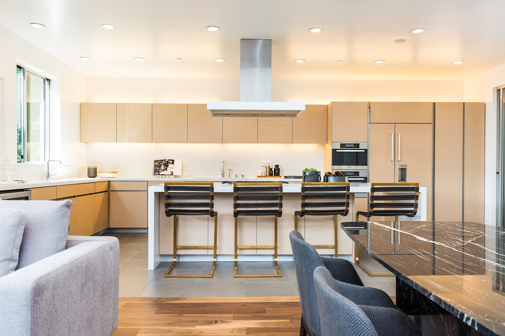 Photo of a contemporary galley open plan kitchen in San Francisco with flat-panel cabinets, light wood cabinets, stainless steel appliances, with island and grey floor.