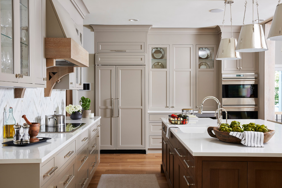 Inspiration for a large transitional eat-in kitchen in Minneapolis with an undermount sink, recessed-panel cabinets, grey cabinets, quartz benchtops, grey splashback, marble splashback, stainless steel appliances, medium hardwood floors, with island, brown floor and white benchtop.