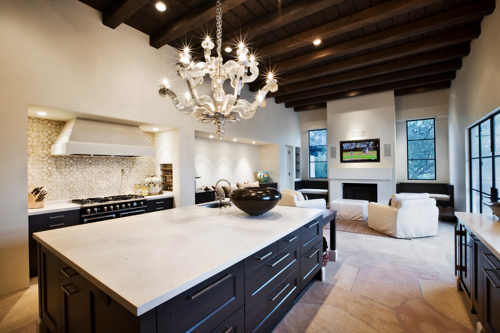 Photo of an expansive contemporary galley eat-in kitchen in Santa Barbara with black cabinets, with island, a drop-in sink, shaker cabinets, quartz benchtops, beige splashback, ceramic splashback, stainless steel appliances and terra-cotta floors.