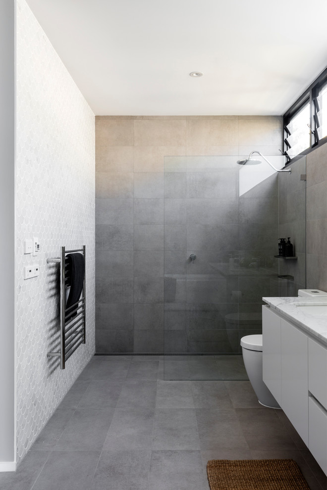 Inspiration for a mid-sized contemporary 3/4 bathroom in Sydney with furniture-like cabinets, light wood cabinets, brown tile, porcelain tile and terrazzo benchtops.