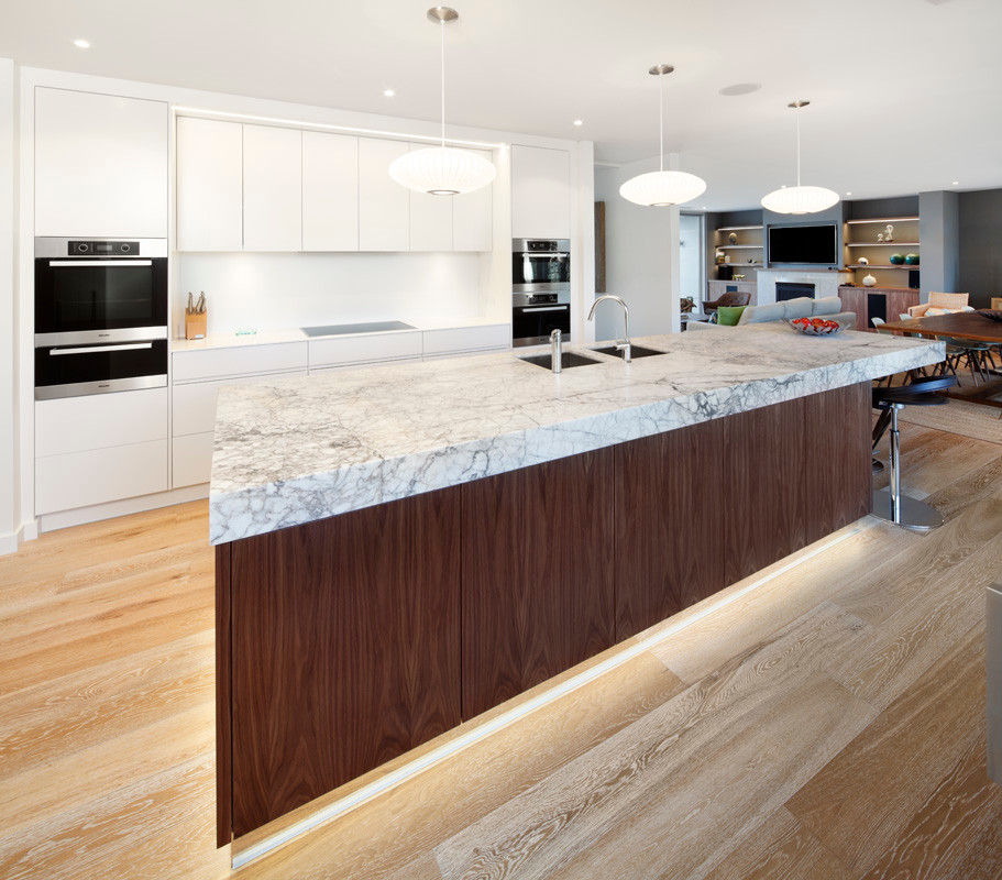 Design ideas for a mid-sized contemporary single-wall eat-in kitchen in Sydney with a double-bowl sink, flat-panel cabinets, white cabinets, marble benchtops, white splashback, stainless steel appliances, light hardwood floors and with island.