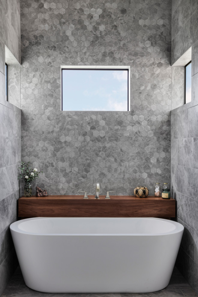 Design ideas for a large modern ensuite bathroom in Austin with shaker cabinets, white cabinets, a freestanding bath, a built-in shower, grey tiles, ceramic tiles, white walls, ceramic flooring, a submerged sink, quartz worktops, grey floors, a hinged door, grey worktops, a shower bench, double sinks and a built in vanity unit.