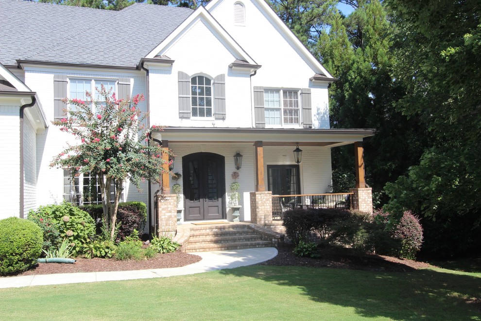 This is an example of a mid-sized transitional front yard verandah in Atlanta with concrete slab and a roof extension.