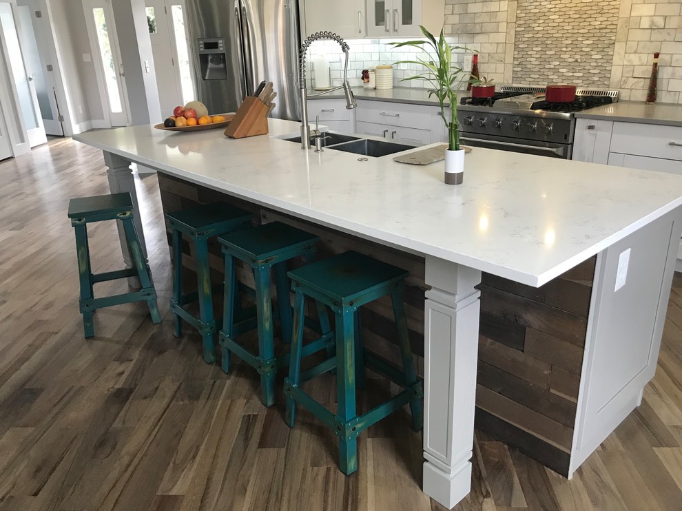 Eat-in kitchen - large transitional single-wall light wood floor and gray floor eat-in kitchen idea in Atlanta with a farmhouse sink, shaker cabinets, white cabinets, quartzite countertops, white backsplash, marble backsplash, stainless steel appliances, an island and white countertops