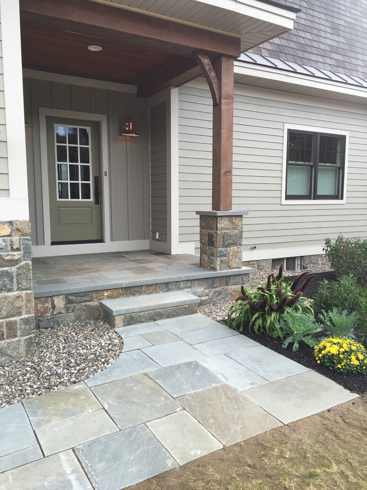 Small country side yard verandah in Boston with natural stone pavers and a roof extension.