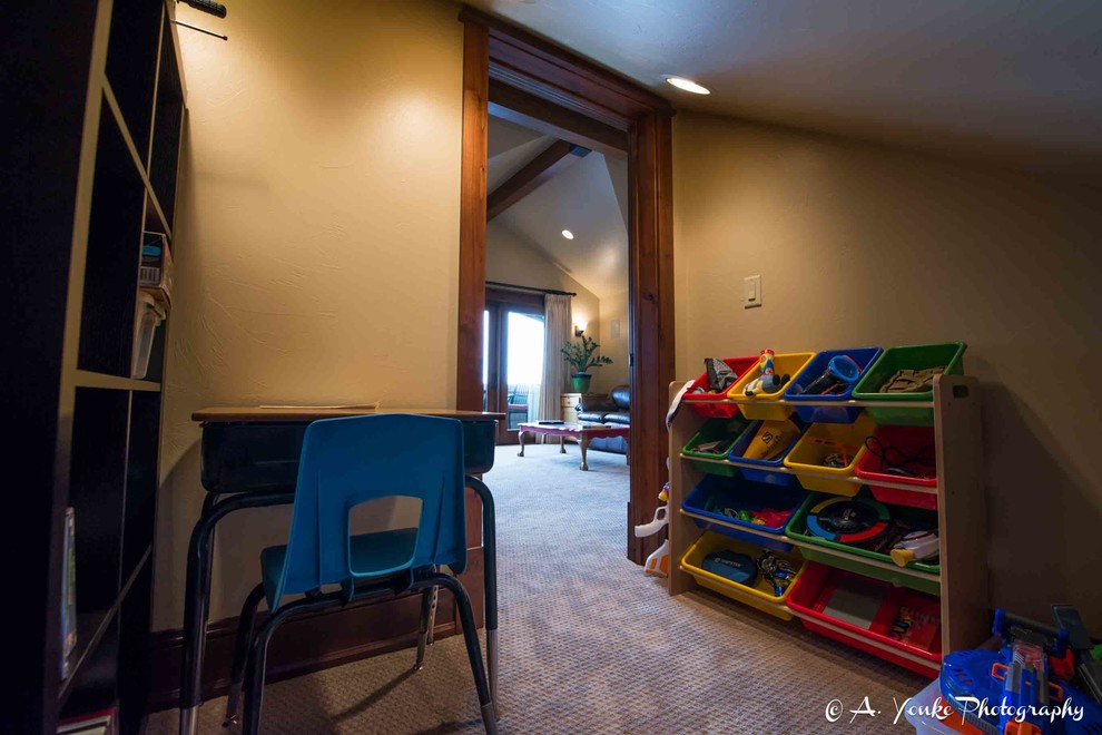 This is an example of a small country gender-neutral kids' playroom in Other with beige walls and carpet.