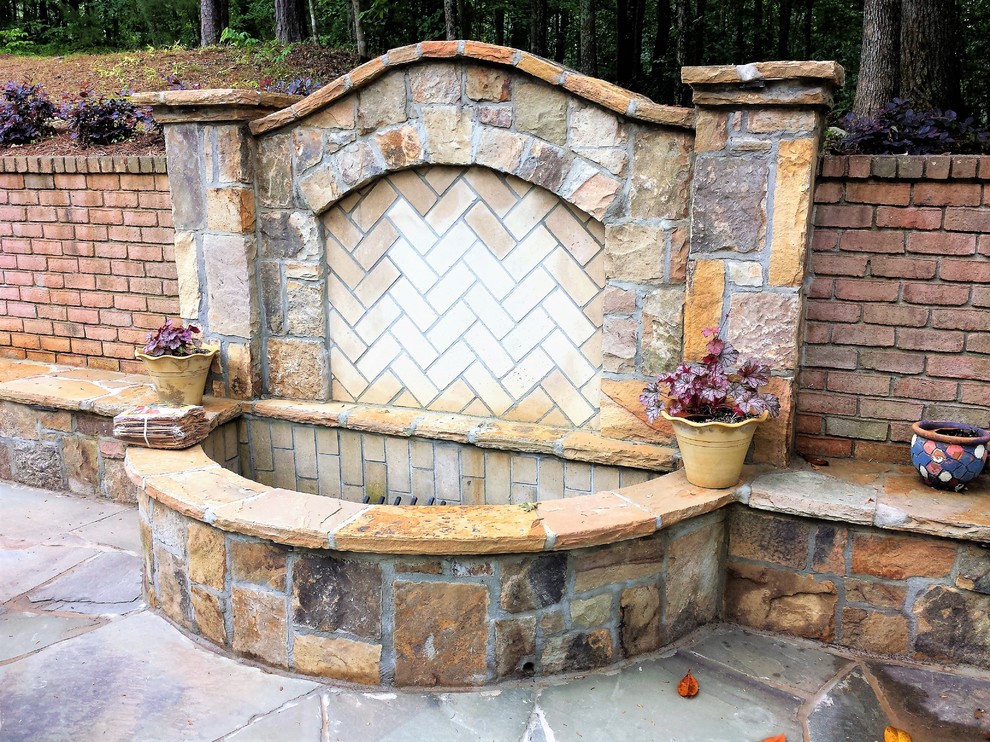 Mid-sized traditional courtyard patio in Atlanta with a fire feature and natural stone pavers.