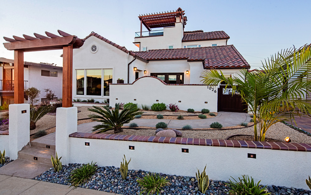Large mediterranean two-storey stucco white exterior in San Diego with a gable roof.