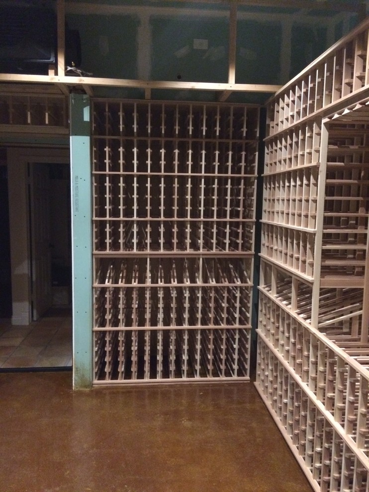 This is an example of a large traditional wine cellar in San Diego with concrete floors and storage racks.