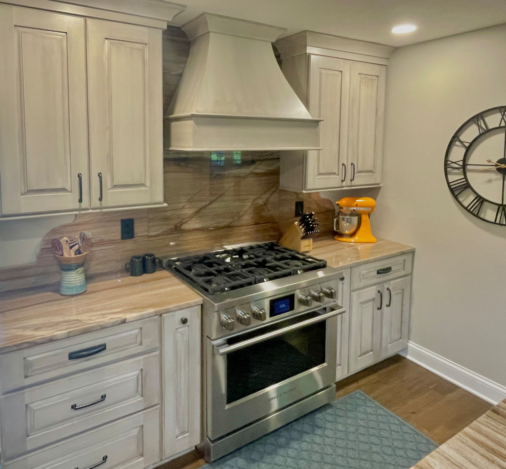 Inspiration for a country brown floor eat-in kitchen remodel with metallic backsplash, an island and multicolored countertops