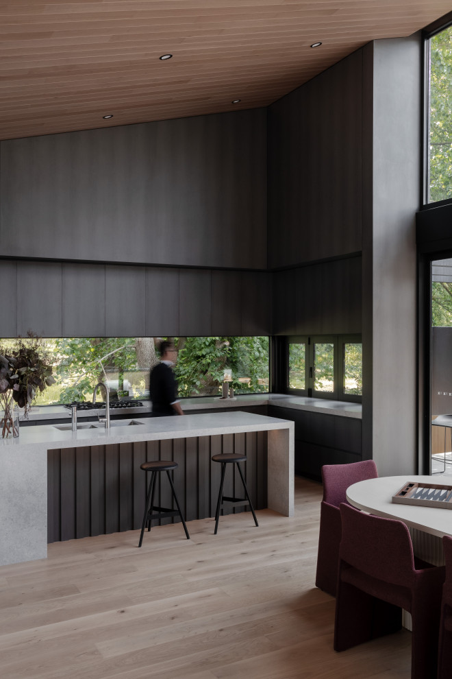 This is an example of a modern l-shaped eat-in kitchen in Melbourne with an undermount sink, flat-panel cabinets, dark wood cabinets, light hardwood floors, with island, beige floor, white benchtop, vaulted and wood.
