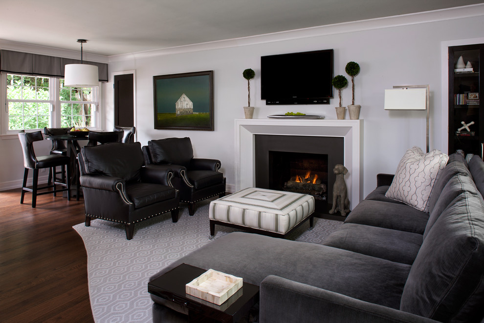 Photo of a transitional formal enclosed living room in Detroit with grey walls, dark hardwood floors, a standard fireplace and a wall-mounted tv.