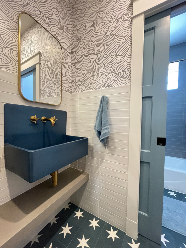 Mid-sized eclectic kids bathroom in Denver with blue cabinets, grey walls, cement tiles, a trough sink, solid surface benchtops, blue floor, a floating vanity and wallpaper.