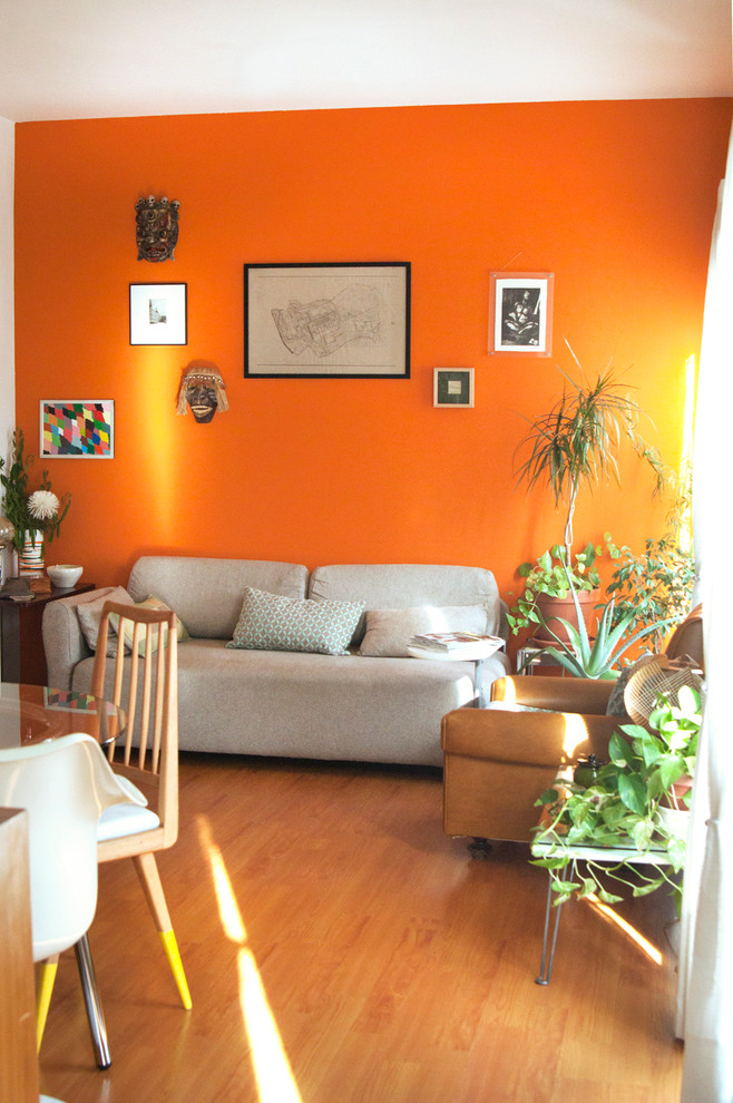 Design ideas for a mid-sized eclectic formal enclosed living room in Dorset with orange walls.