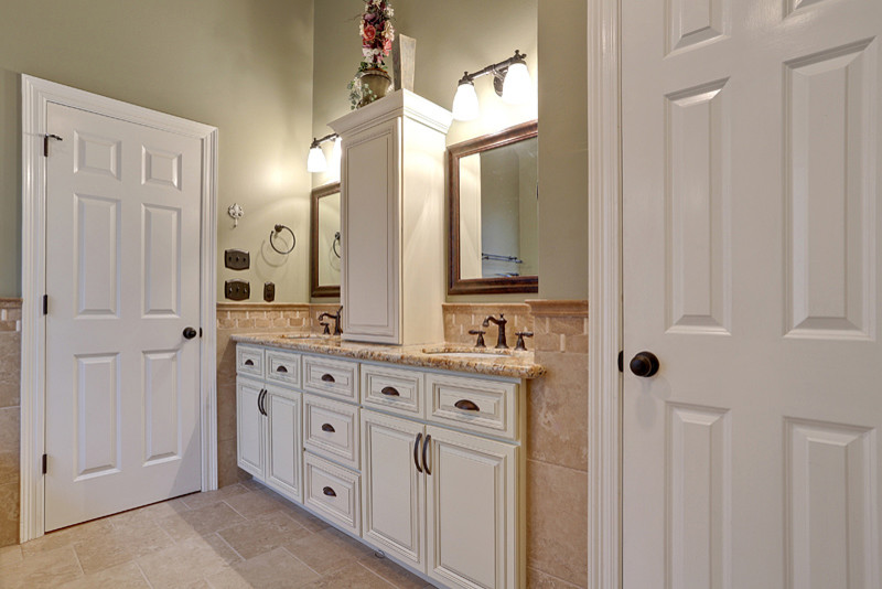 Photo of a traditional bathroom in New Orleans with an undermount sink, raised-panel cabinets, white cabinets, granite benchtops, a drop-in tub, an open shower, beige tile and porcelain tile.