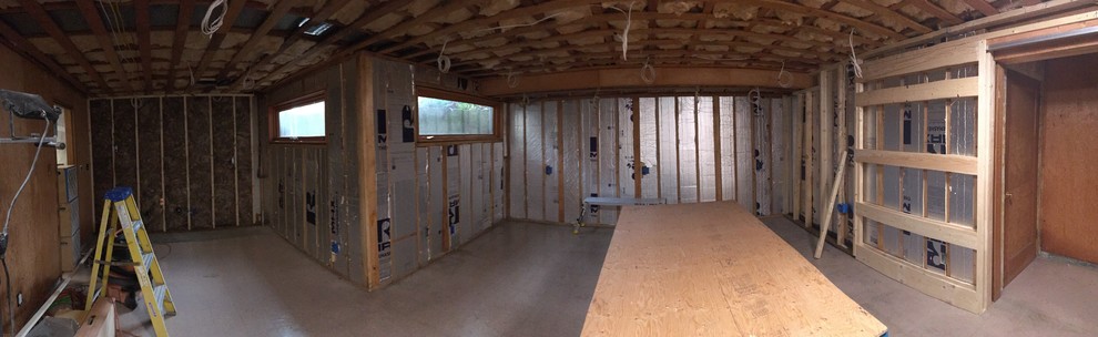 Example of a mid-sized mountain style underground laminate floor and brown floor basement design in Seattle with green walls and a wood stove