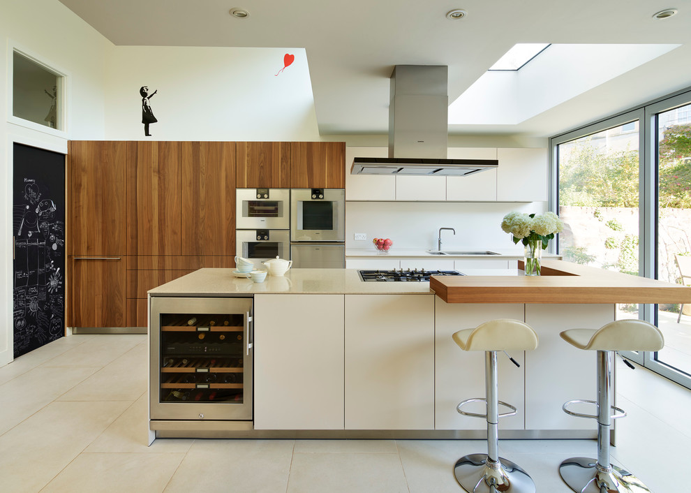 Design ideas for a large contemporary galley open plan kitchen in Other with flat-panel cabinets, medium wood cabinets, solid surface benchtops, white splashback, stainless steel appliances, concrete floors, with island and a double-bowl sink.