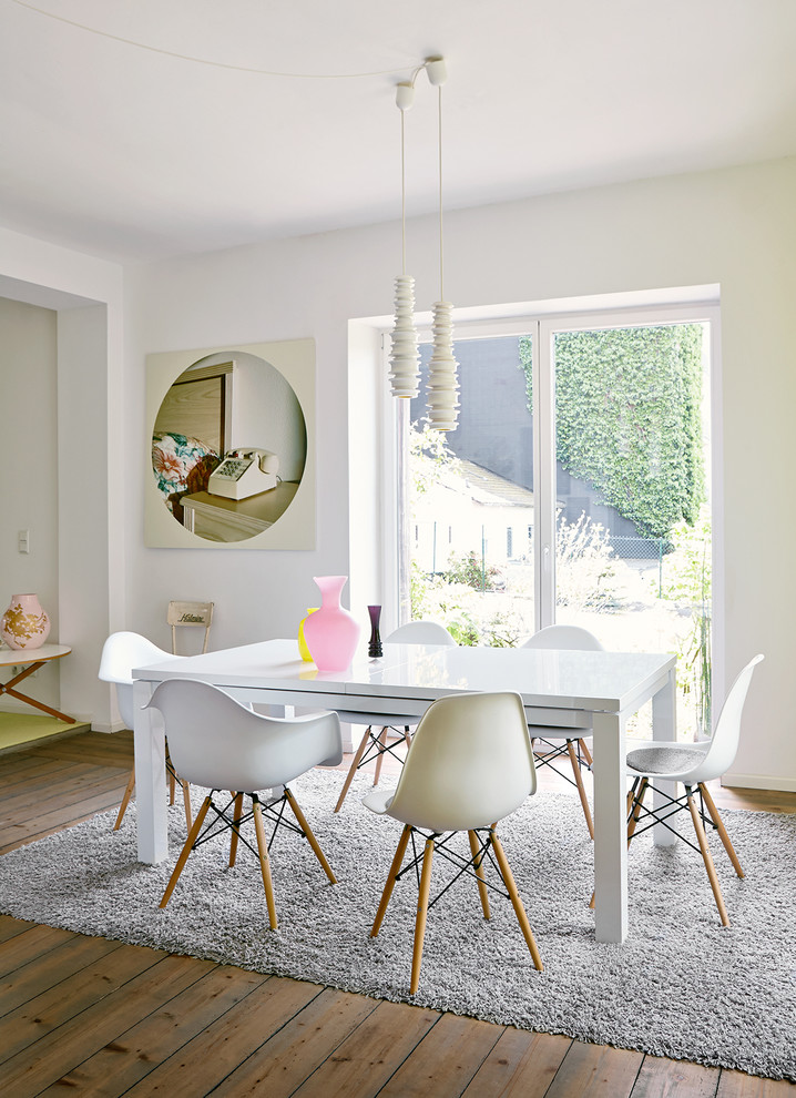 Inspiration for a contemporary dining room in Hamburg with white walls and medium hardwood floors.