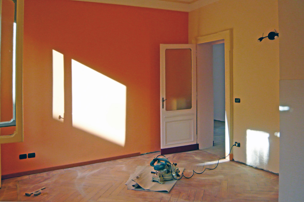 Cette image montre une grande salle à manger ouverte sur la cuisine traditionnelle avec un sol marron, un mur orange et parquet foncé.