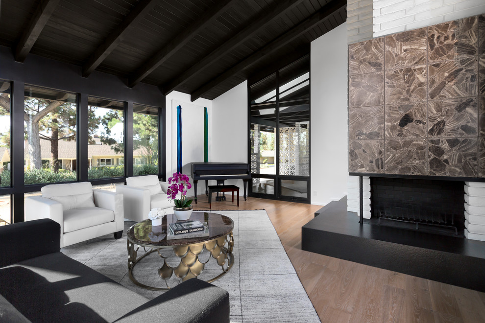 Inspiration for a large midcentury formal open concept living room in Orange County with white walls, light hardwood floors, a corner fireplace, a stone fireplace surround, no tv and beige floor.
