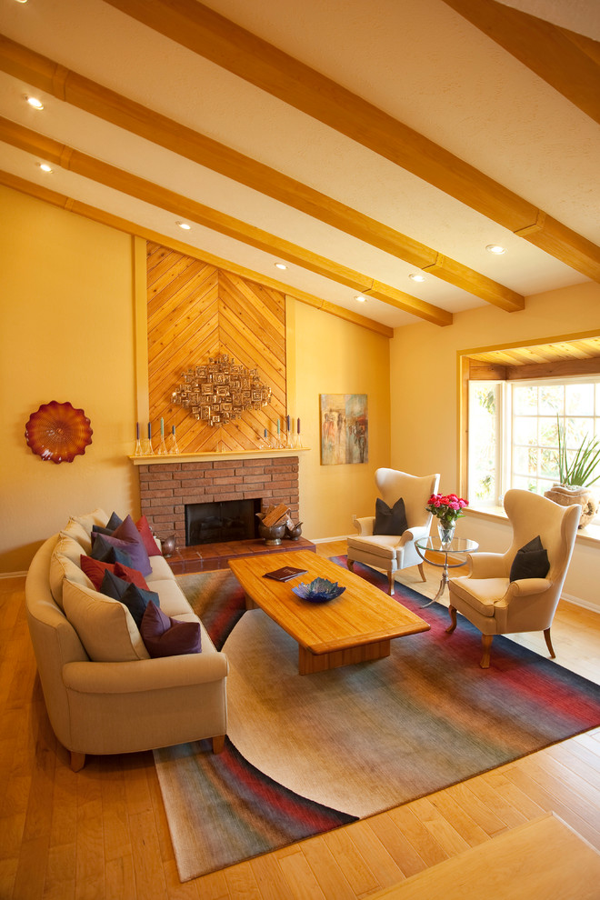 Mid-sized contemporary open concept living room in Los Angeles with beige walls, light hardwood floors, a standard fireplace and a brick fireplace surround.