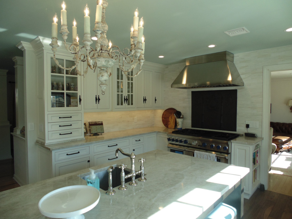 Large transitional u-shaped medium tone wood floor and brown floor eat-in kitchen photo with an undermount sink, recessed-panel cabinets, white cabinets, quartzite countertops, beige backsplash, subway tile backsplash, stainless steel appliances, an island and beige countertops