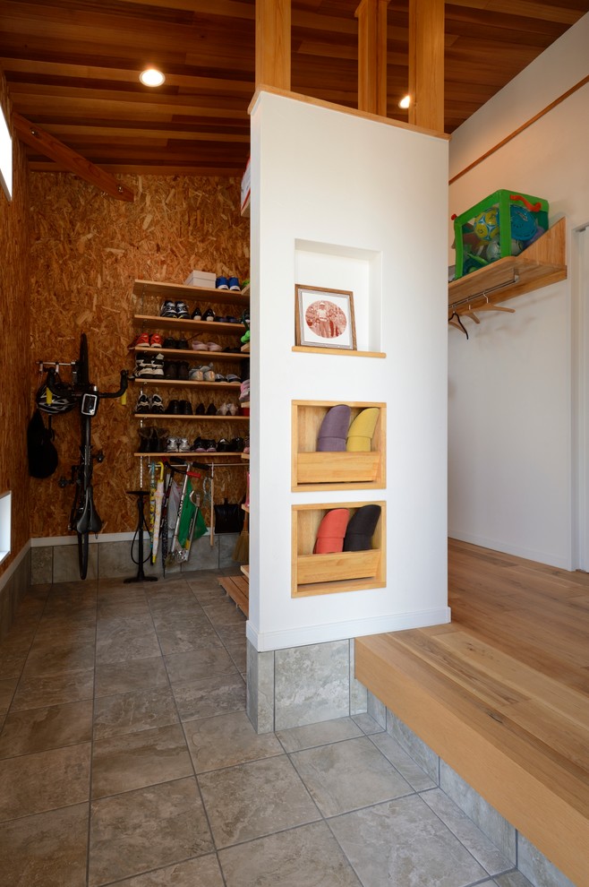 This is an example of a mid-sized industrial mudroom in Other with white walls.