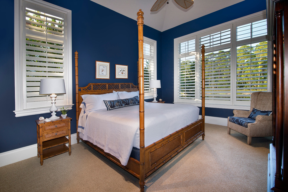 Photo of a mid-sized tropical guest bedroom in Miami with blue walls, carpet, no fireplace and brown floor.
