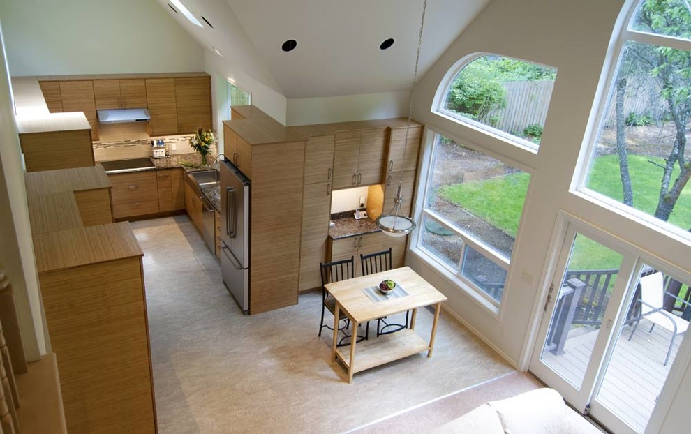 Inspiration for a mid-sized transitional u-shaped open plan kitchen in Seattle with a farmhouse sink, flat-panel cabinets, medium wood cabinets, quartz benchtops, beige splashback, glass tile splashback, stainless steel appliances, linoleum floors, no island, vaulted and black benchtop.