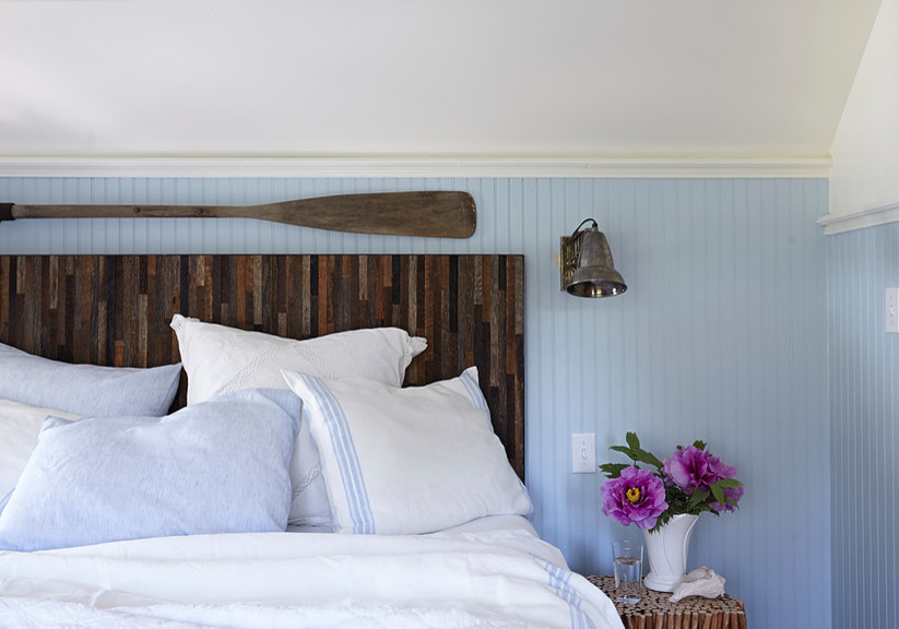 Mid-sized beach style guest bedroom in Other with blue walls and no fireplace.